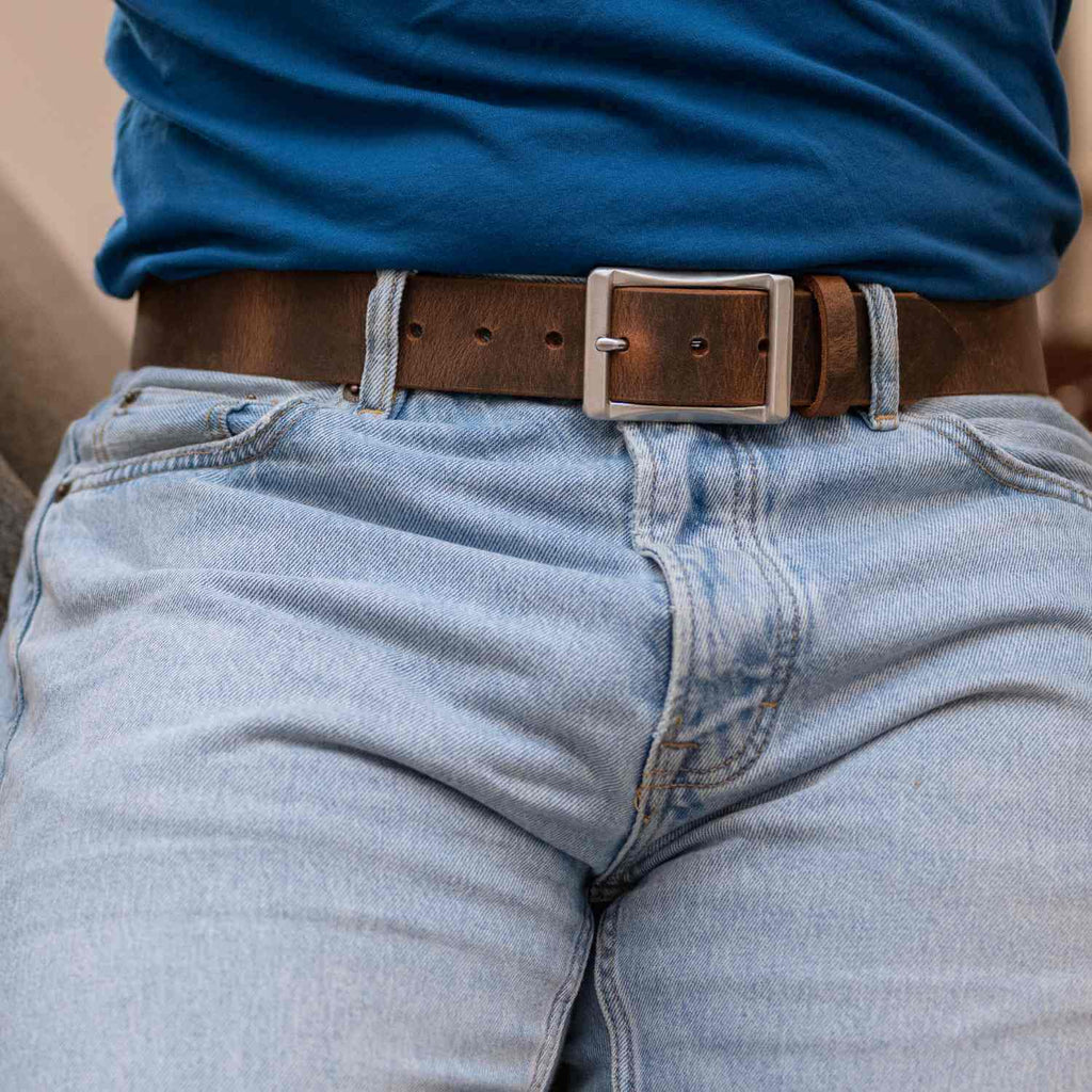 Site Manager Distressed Brown Leather Belt on model wearing blue jeans and blue t-shirt.