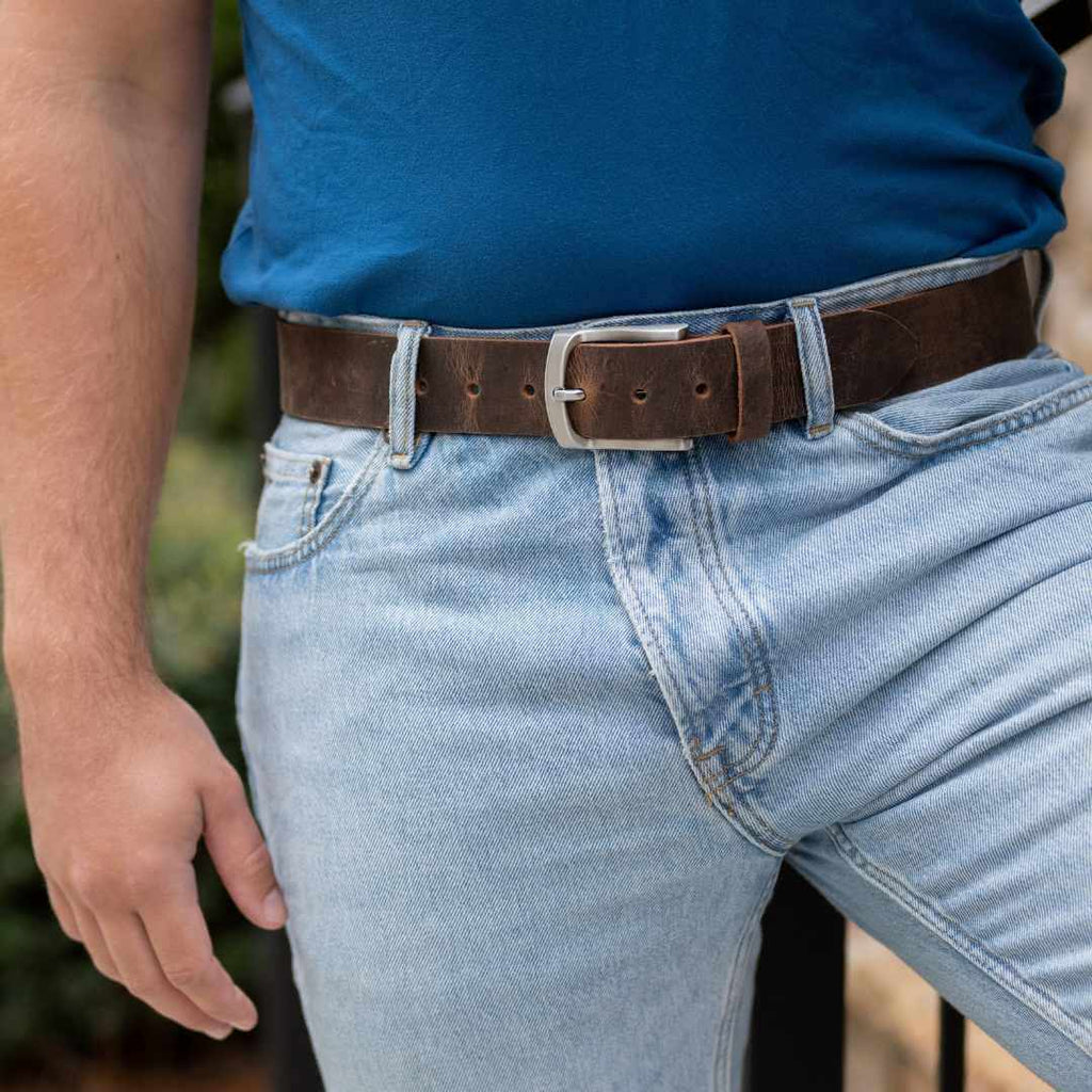 Silver, curved low profile buckle for sleek design with 1.5 inch distressed brown leather strap