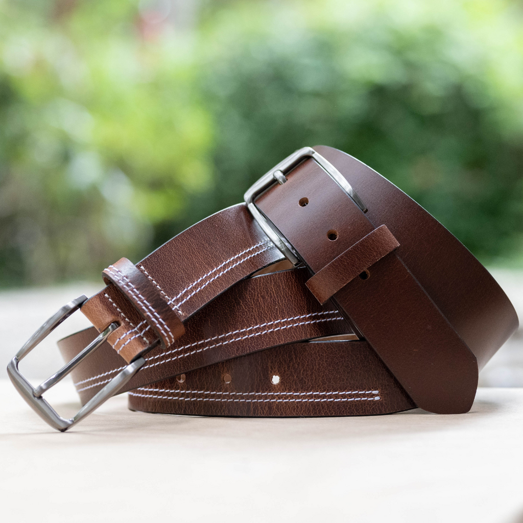 Millennial Brown Leather Belt Set. Outdoor setting. 1 solid brown, 1 with double white stitch.