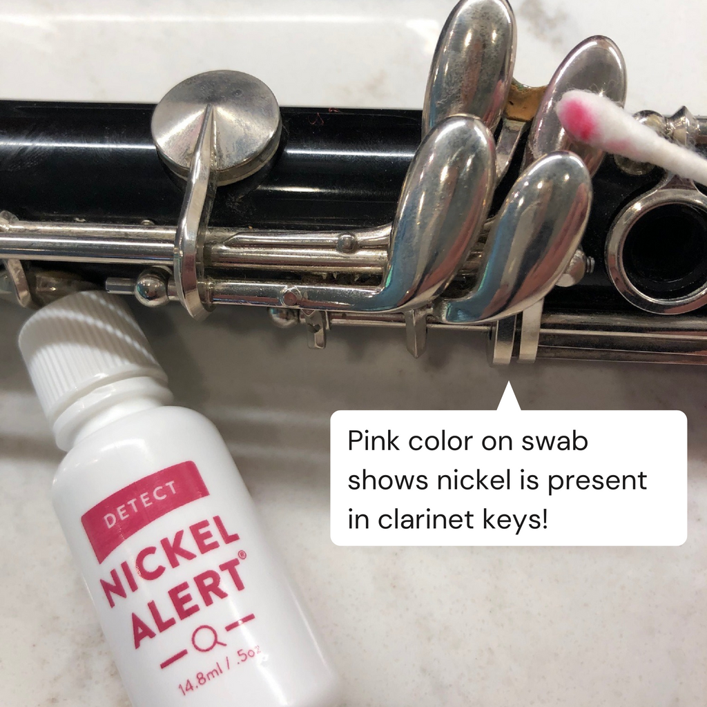 Image of Nickel Alert testing keys on a clarinet. Pink color on swab indicates nickel in clarinet keys